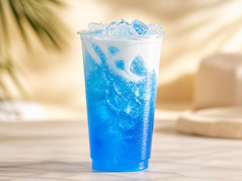 Bright blue raspberry coconut energy drink over ice in a clear cup